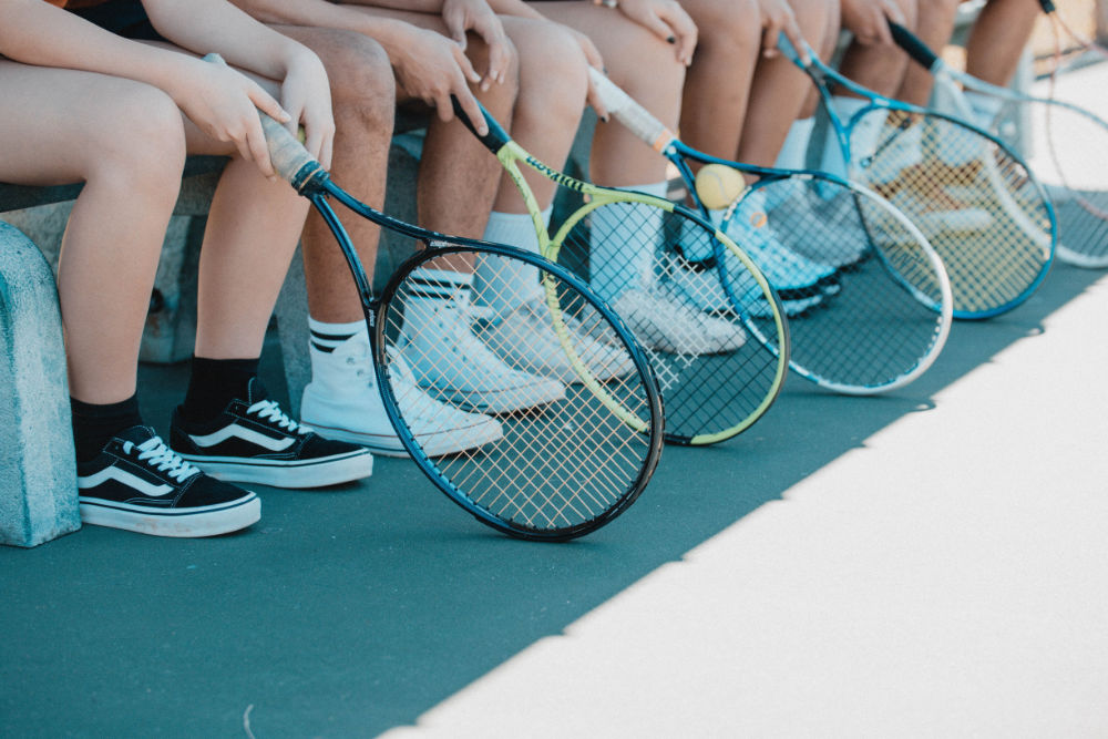 Tennisspieler sitzen auf einer Bank
